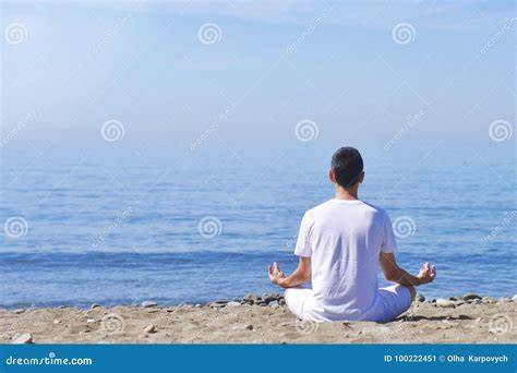 Persona in meditazione davanti al mare